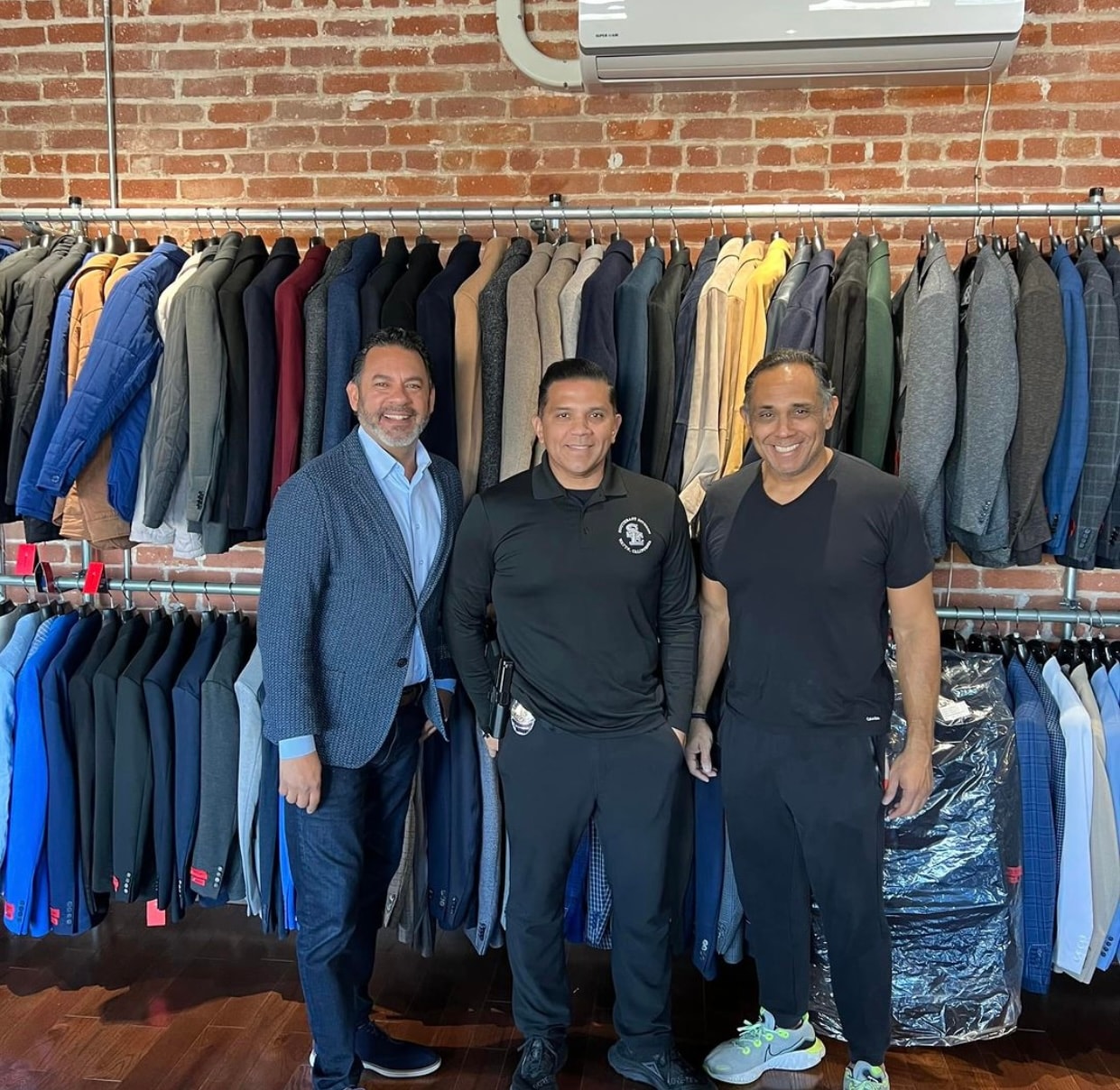 Luis Arandia guiding a client through jacket selection in a menswear boutique
